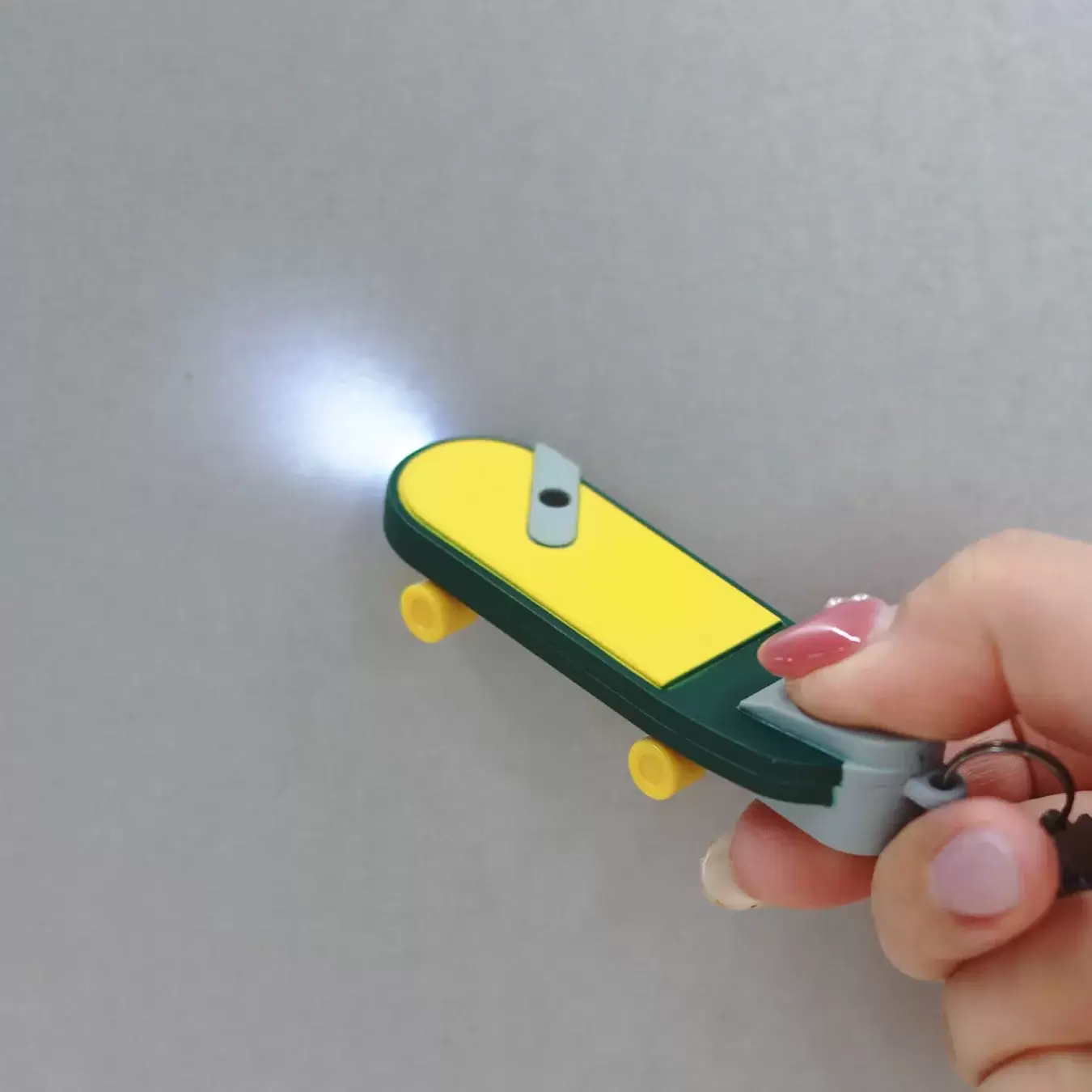 スケートボード型のLEDライトを手で持っている様子