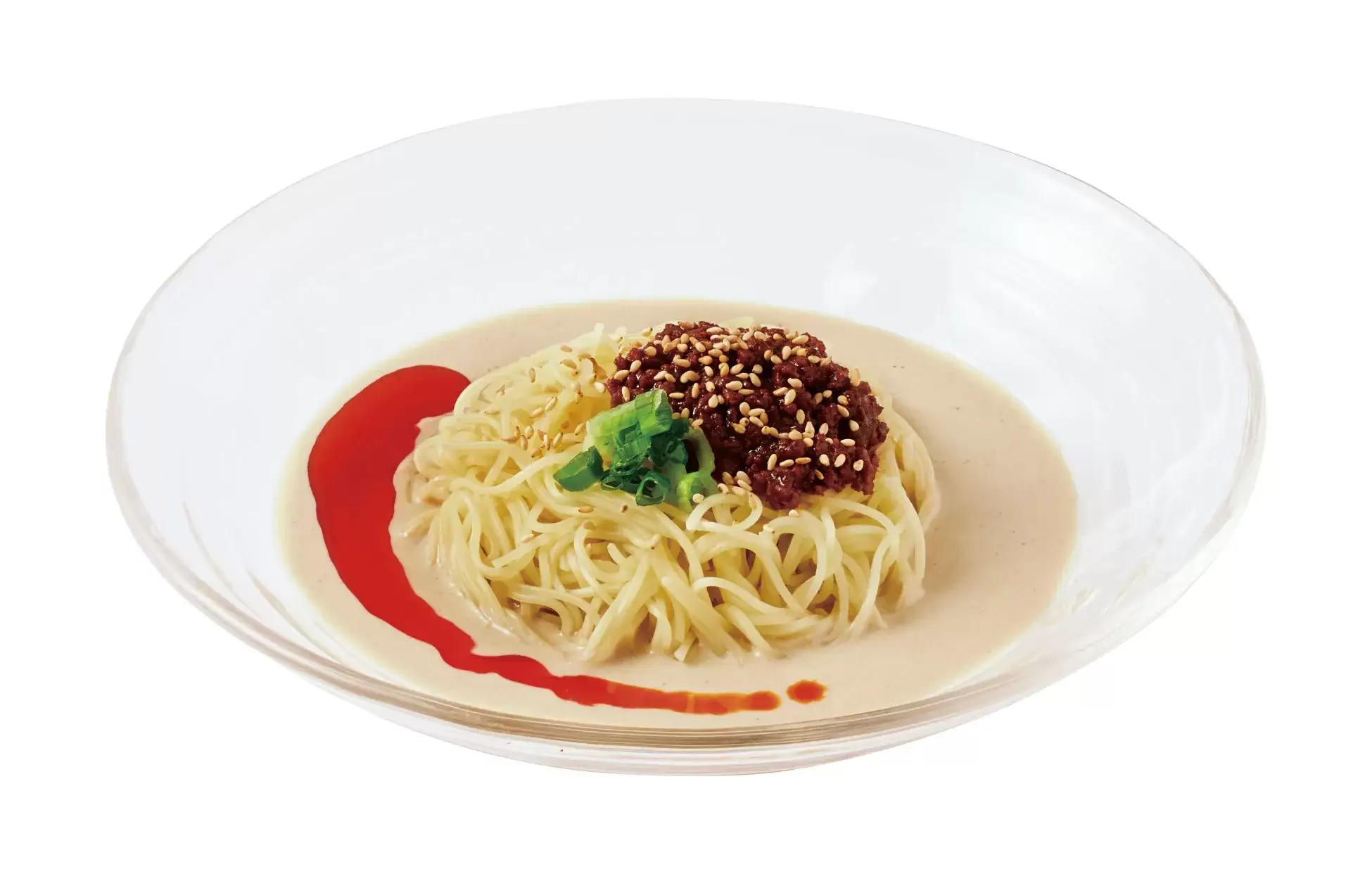 透明なガラスの器に入った冷やし中華。麺の上にひき肉とごまがたっぷりかかっている。赤いソースが添えられている。